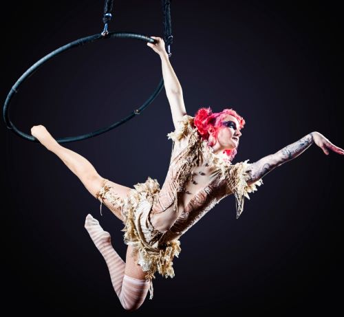 a woman in a costume is performing a trick on a hoople