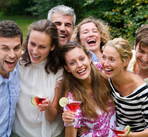 a group of people standing around a table with drinks