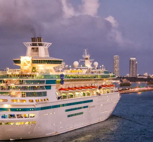 a cruise ship in the water with a city in the background