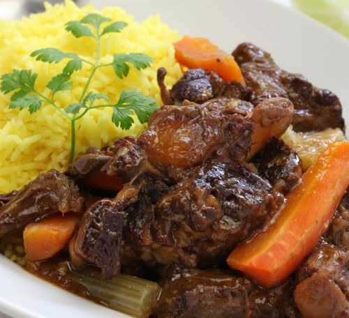 a plate of food with rice, meat and vegetables