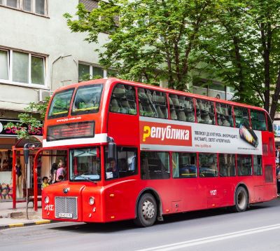 a red double decker bus parked on the side of a street