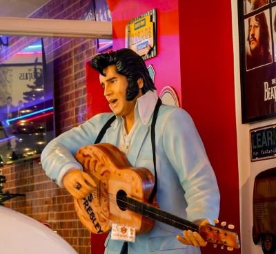 a statue of elvis presley playing guitar in a restaurant