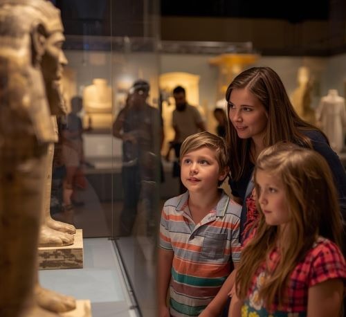 a woman and two children in a museum