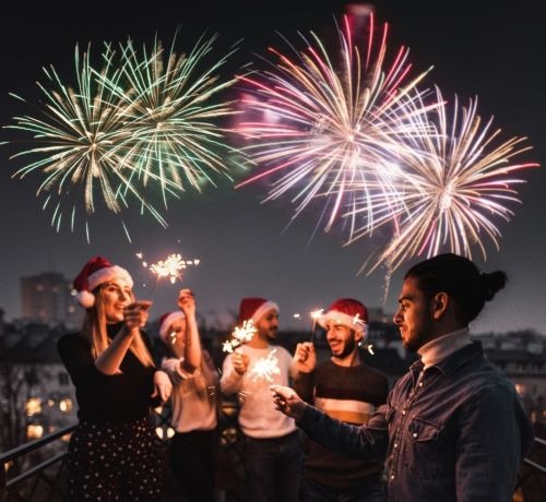 a group of friends celebrating at new years eve with fireworks