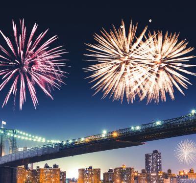 nyc - fireworks in the sky over a bridge and a city