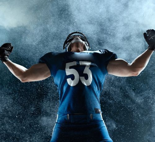 a man in a football uniform holding a football ball
