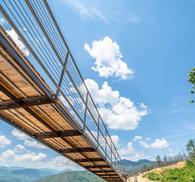 a bridge crossing a river in the mountains