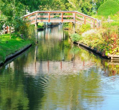 Giethoorn - a bridge over a river with a bridge over it
