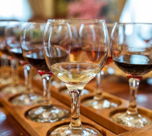 a row of wine glasses with wine glasses on a table