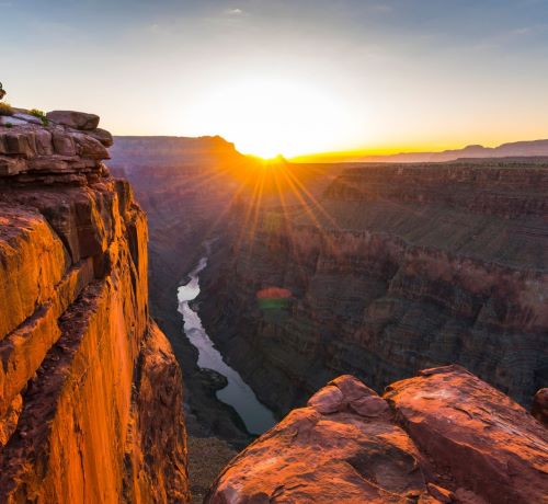a man standing on a cliff overlooking a river