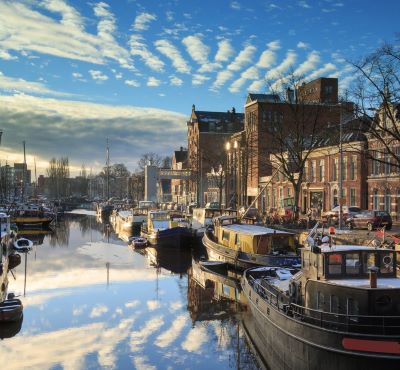 groningen - a river with boats and buildings in the background
