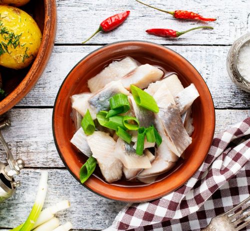 a bowl of fish with a spoon and a fork
