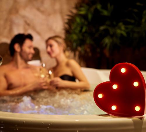 a man and woman in a JACUZZI with a heart shaped light up