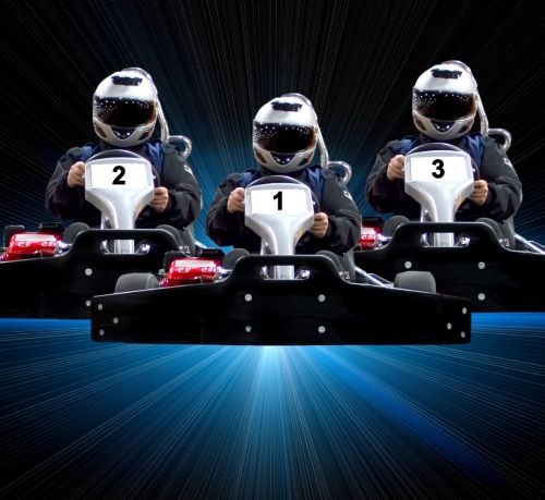 three people in helmets are racing on a race track
