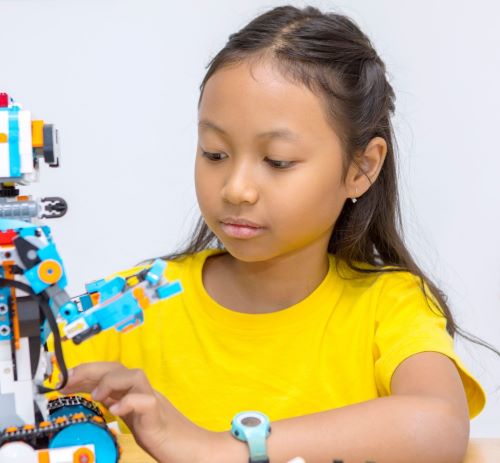 a young girl is playing with a robot toy