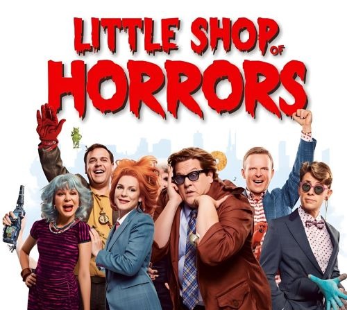 a group of people standing in front of a poster with the sign “little horrors”