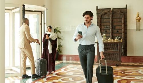 a man in a suit case walking through a hotel lobby