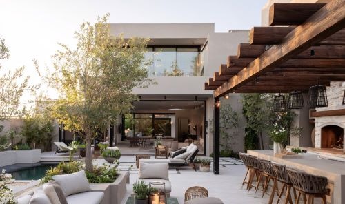 a patio at a luxury hotel with a fireplace and a table with chairs