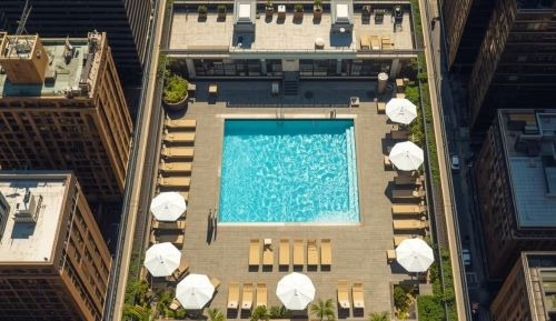 a swimming pool and lounge chairs at a luxury hotel in new york city
