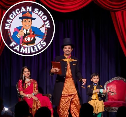 a performing magician on stage with help of a child and a woman
