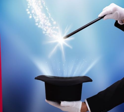 a magician's hand holding a magic wand wand over a magician hat