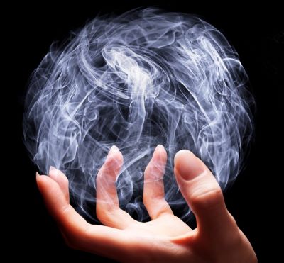 magic - a person holding a ball of smoke on a black background