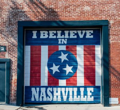 a garage door with a mural of a flag on it with the text “I Believe in Nashville”