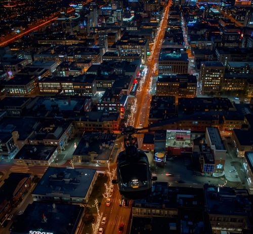a helicopter flying over a city at night