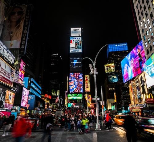 a busy intersection in new york city at night