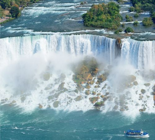 a boat in the water near a waterfall