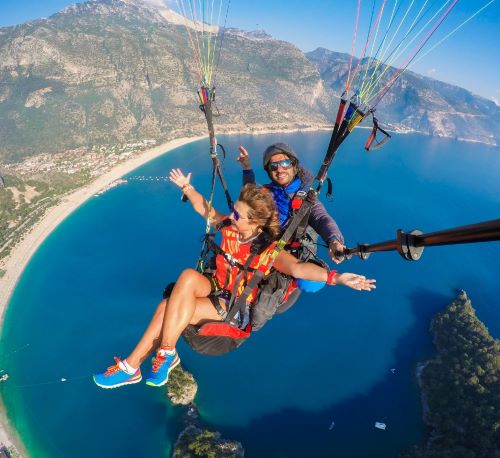 a couple parasailing over a body of water