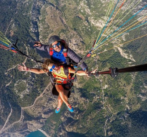 a man and woman parasailing in a parachute