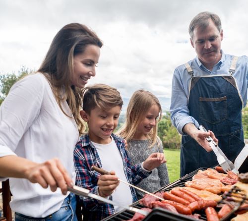 a family cooking together in a barbecue grill