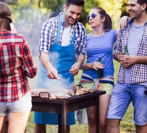 a group of people standing around a grill