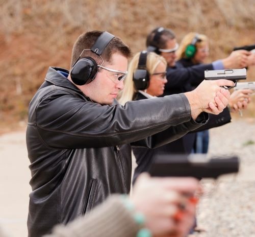 a man in a leather jacket and earphones on a shooting range