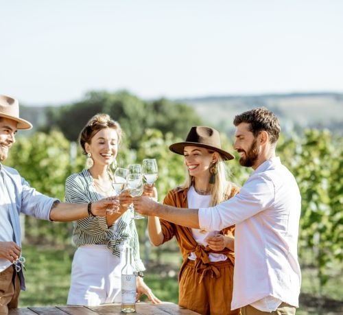 a group of people standing around a table with wine glasses