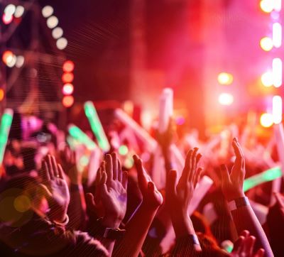 a crowd of people standing in front of a stage with bright lights