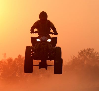 a person riding a quad - atv atv in the sun