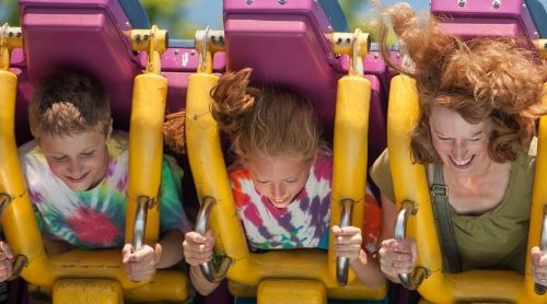 a woman and her two children on a roller coaster