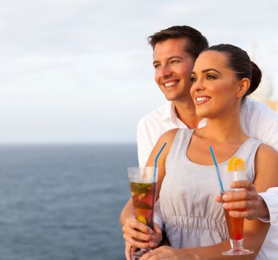 a man and woman holding drinks on a cruise ship