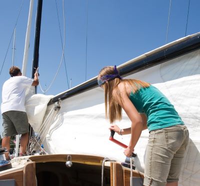 a woman standing on a boat with a man on it