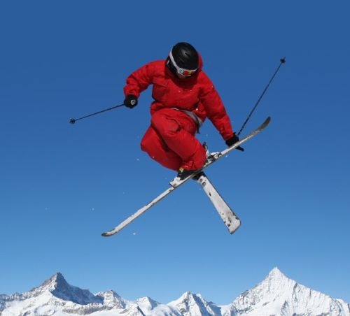 a person in a red jacket and skis in the air