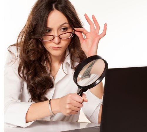 a woman in glasses looking at a laptop computer screen