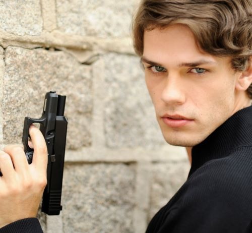 a man in a black jacket holding a gun