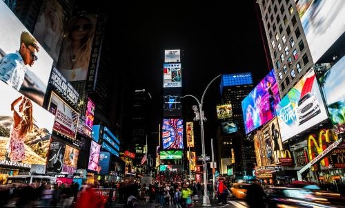 times square new york at night with a lot of people walking around