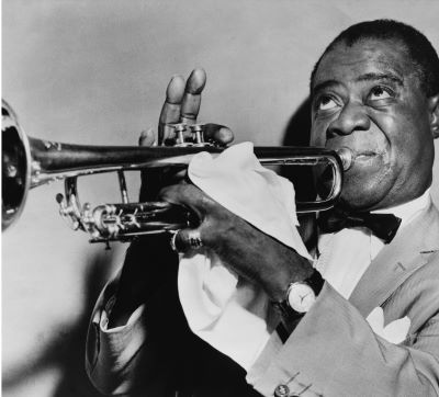 a man in a suit and bow tie playing the trumpet