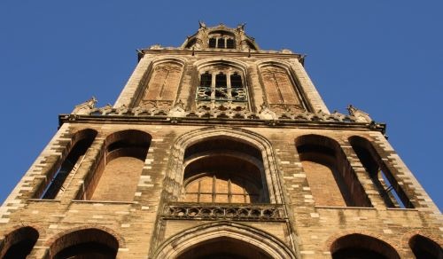 a tall tower in utrecht with a clock on top of it