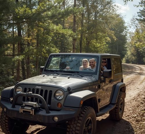 a man driving a jeep with two children