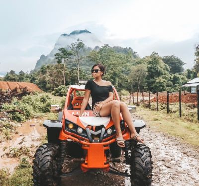 a woman sitting on a atv with a mountain in the background