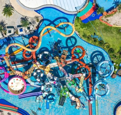 Aerial view of a colorful water park with winding slides and pool play areas for family fun.